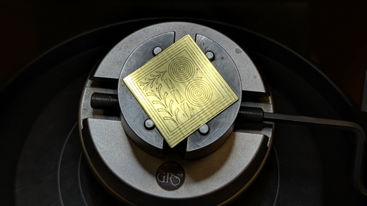 A square brass plate with scroll designs for hand engraving