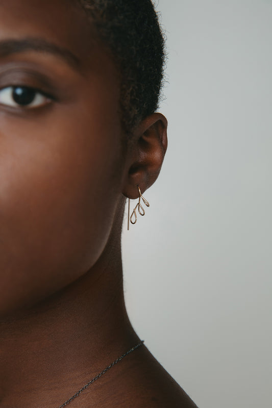 model wearing 14k gold floral earrings