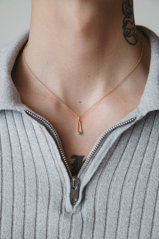 male model wearing gold sapphire teardrop charm pendant necklace