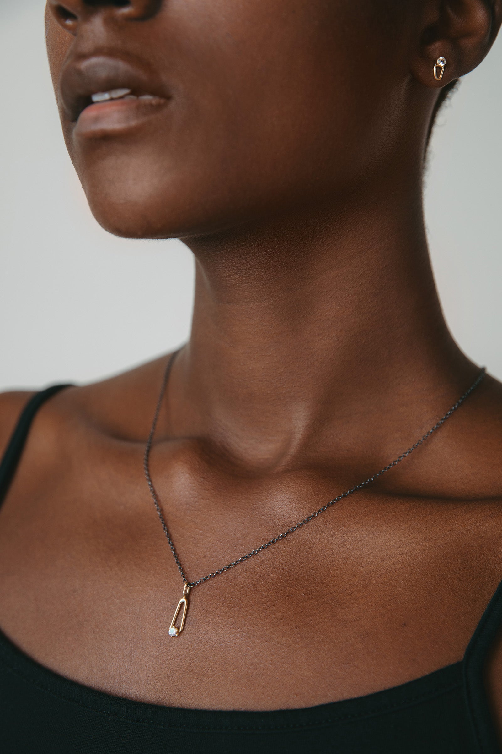 model wearing gold diamond studs with gold moonstone necklace