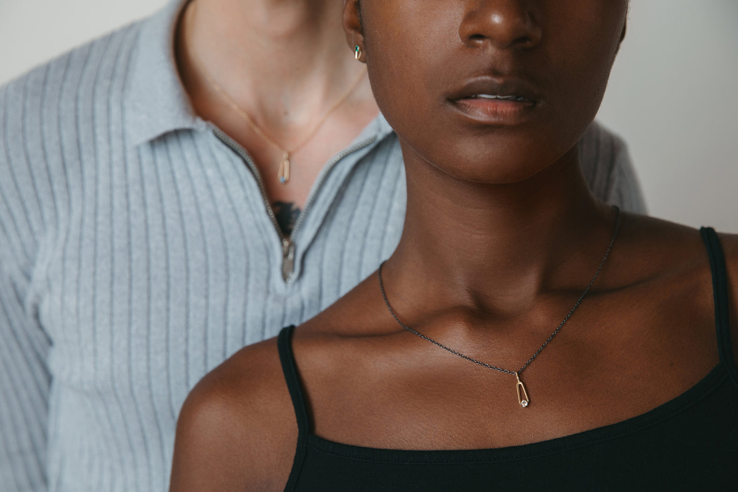 models wearing teardrop birthstone pendant necklace in gold and charcoal silver