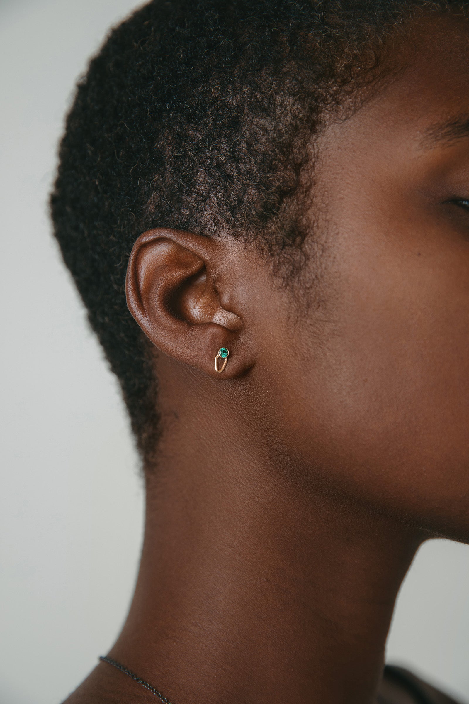 model wearing 14K gold emerald stud earrings