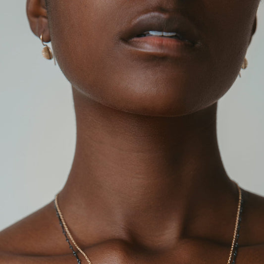 dainty textured 14k gold disk earrings on model