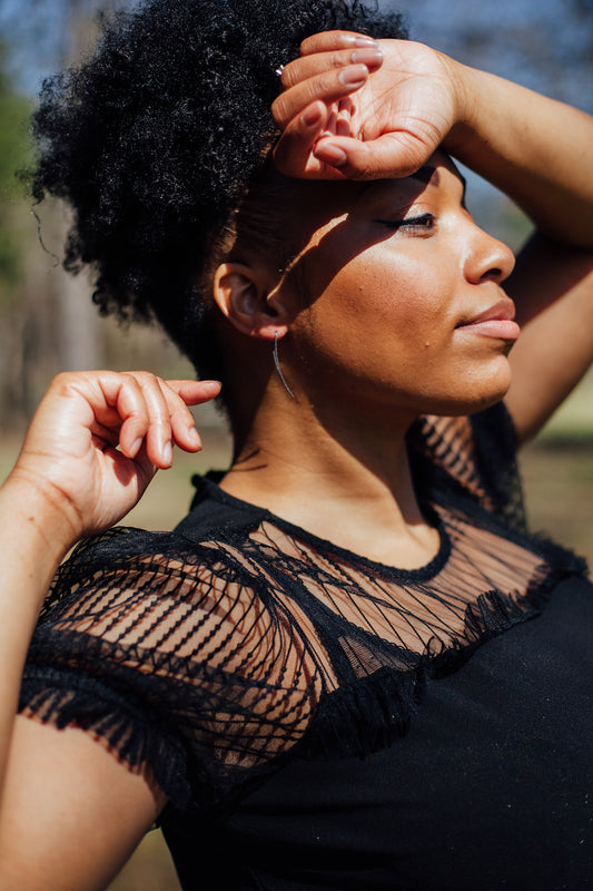 A model wearing silver curved bar threader hoops