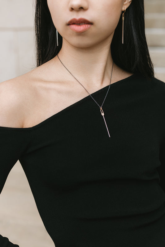 silver and gold knife-edge bar pendant necklace styled with matching earrings on model