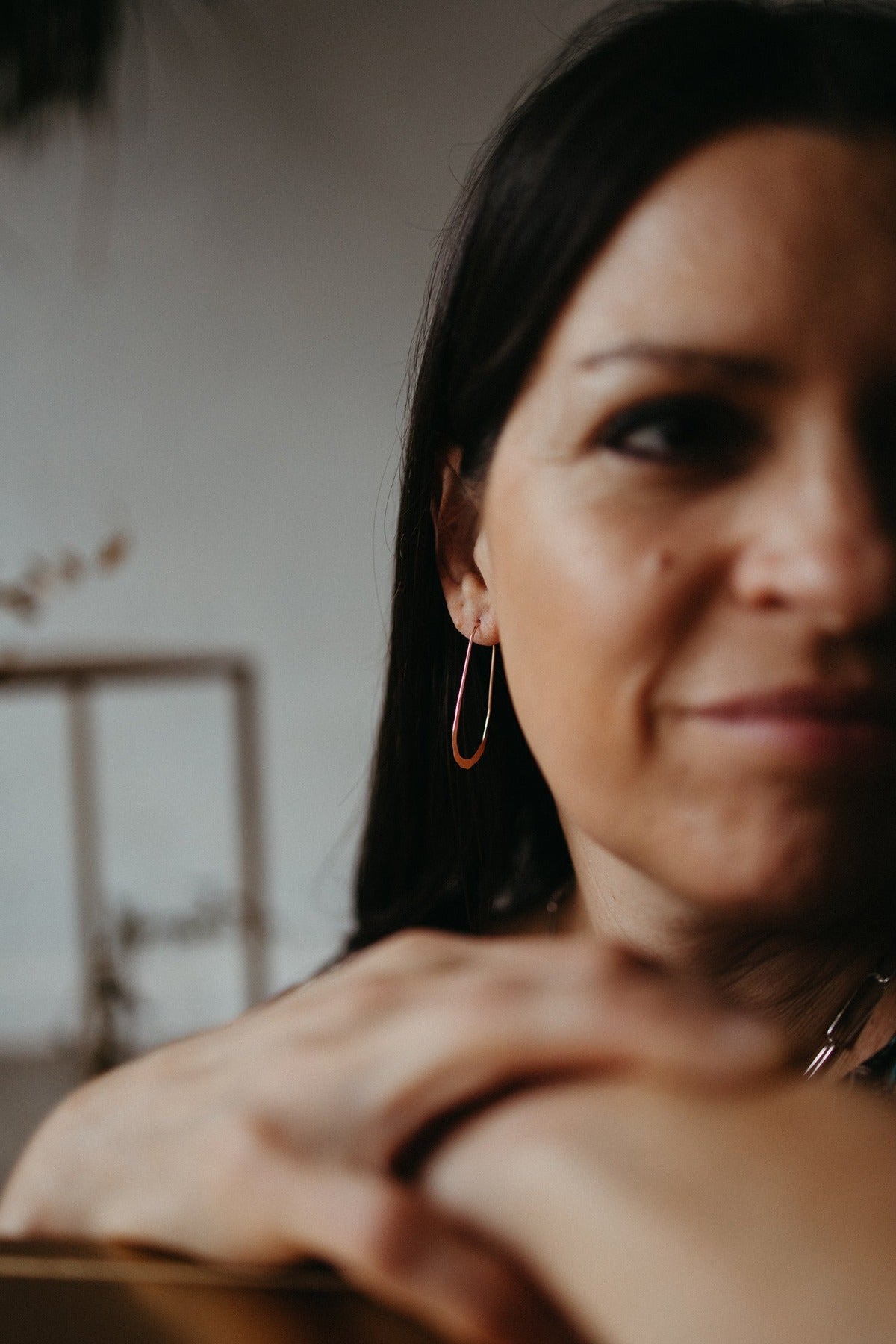 Rose gold oval wire hoop earring styled on model