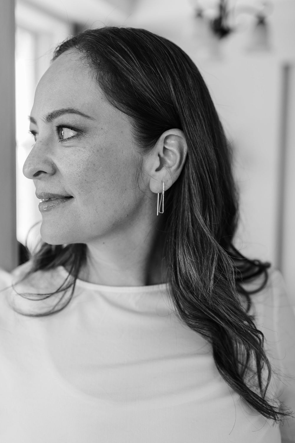 Model wearing silver geometric wire threader hoop earrings