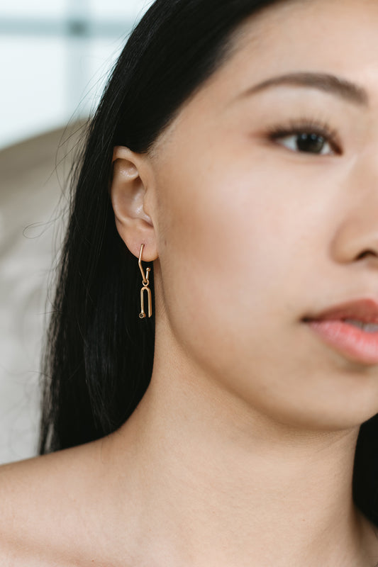 14K yellow gold arch charm with black diamond on model