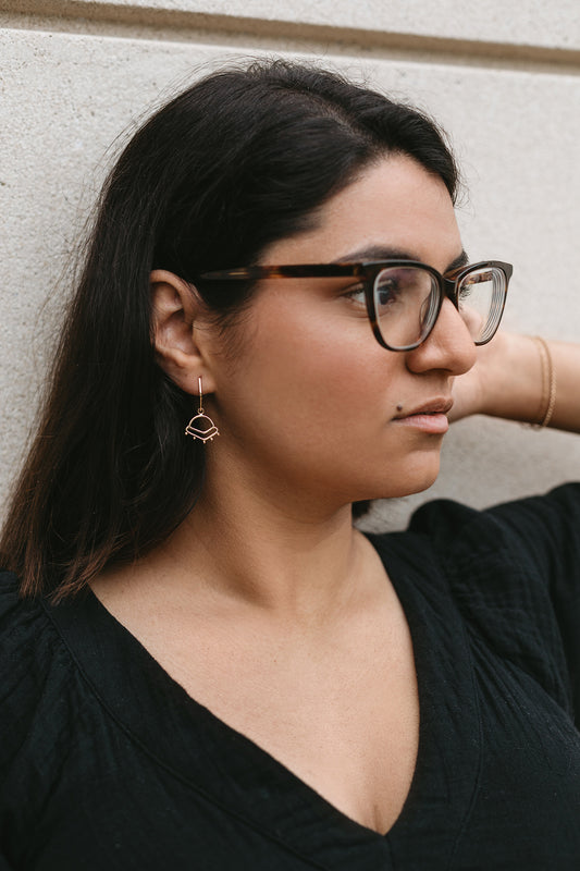 14K gold sunrise-inspired charm styled on model