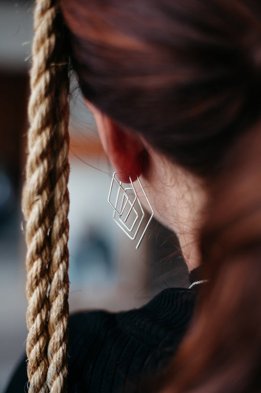 model stacking two pairs of silver wire hoop earrings