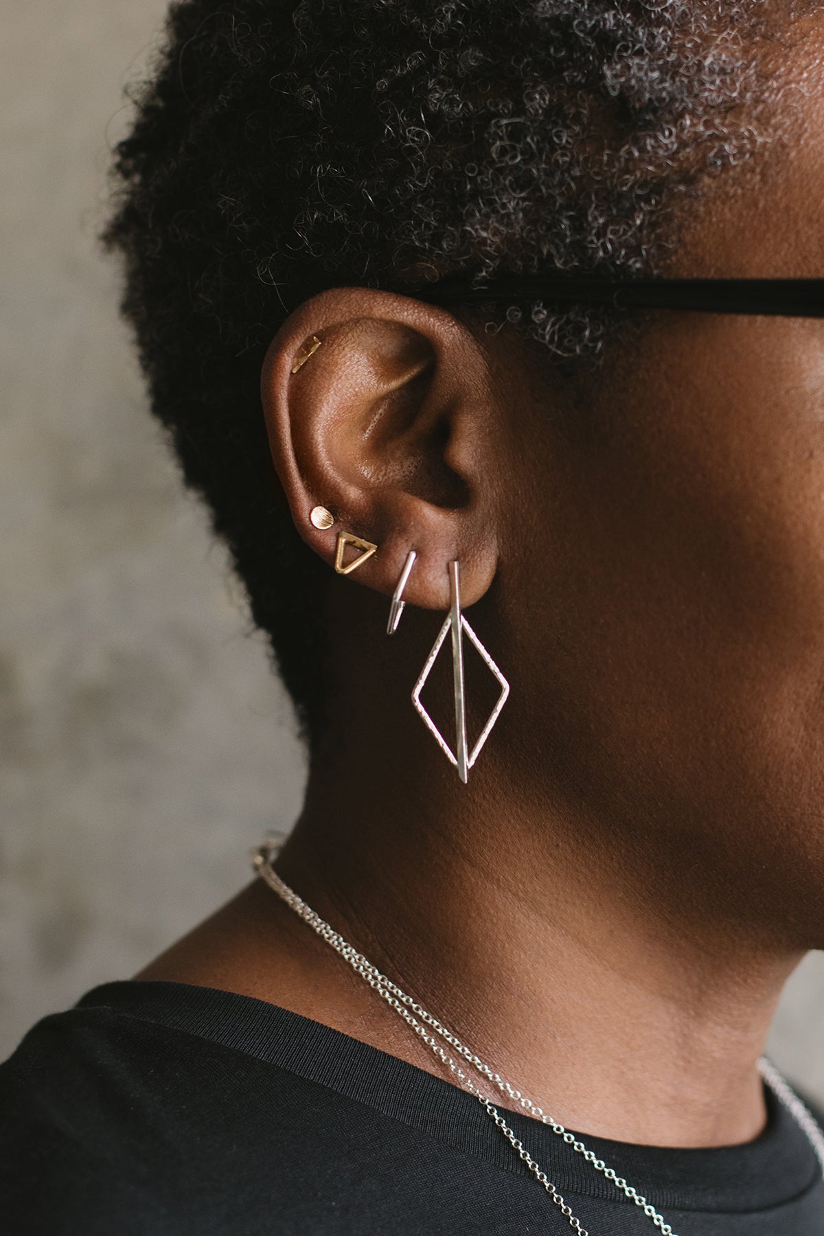 petite silver diamond halo and bar post earrings styled in an earring stack on model