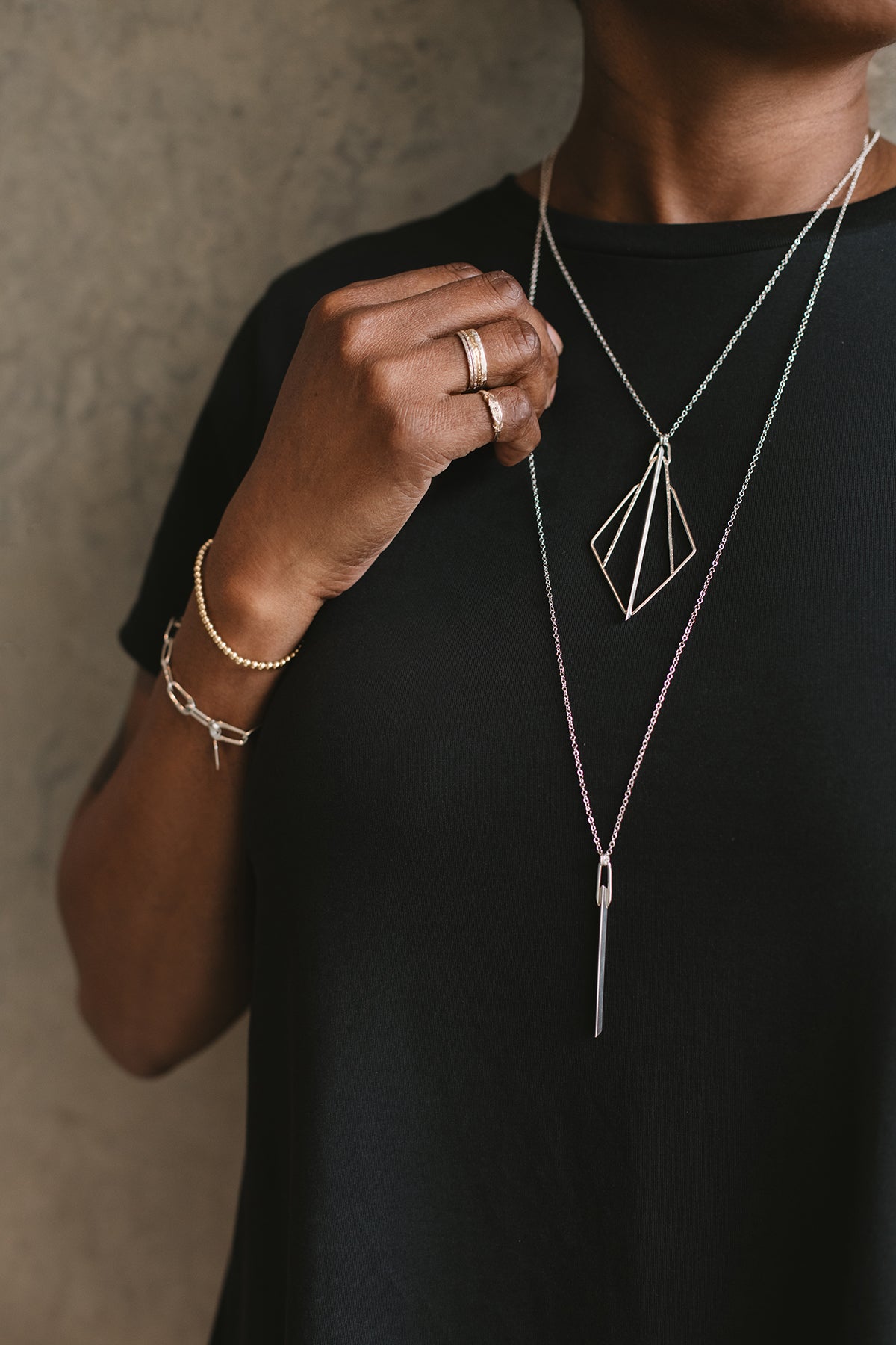 model wearing silver knife-edge bar pendant necklace and oval link bracelet