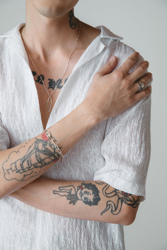 Silver Dagger point necklace with oval chain link bracelet styled on model