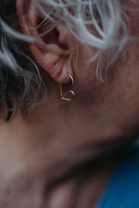 Dainty threader heart-shaped hoop earrings in 14k gold on model