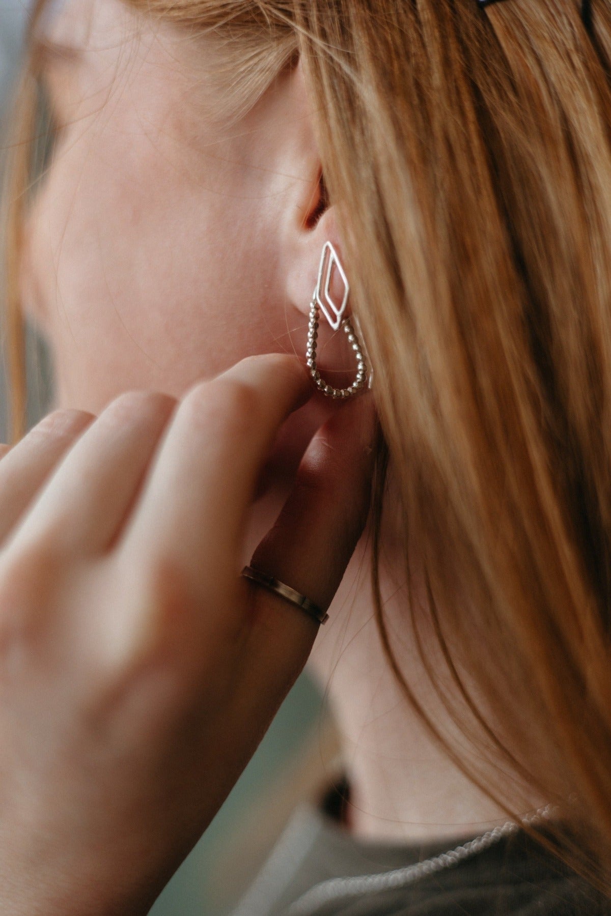 asymmetrical diamond stud earrings in silver on model