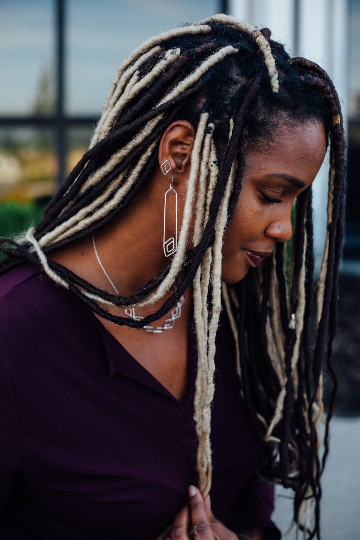 Diamond-shaped stud post earrings styled on model