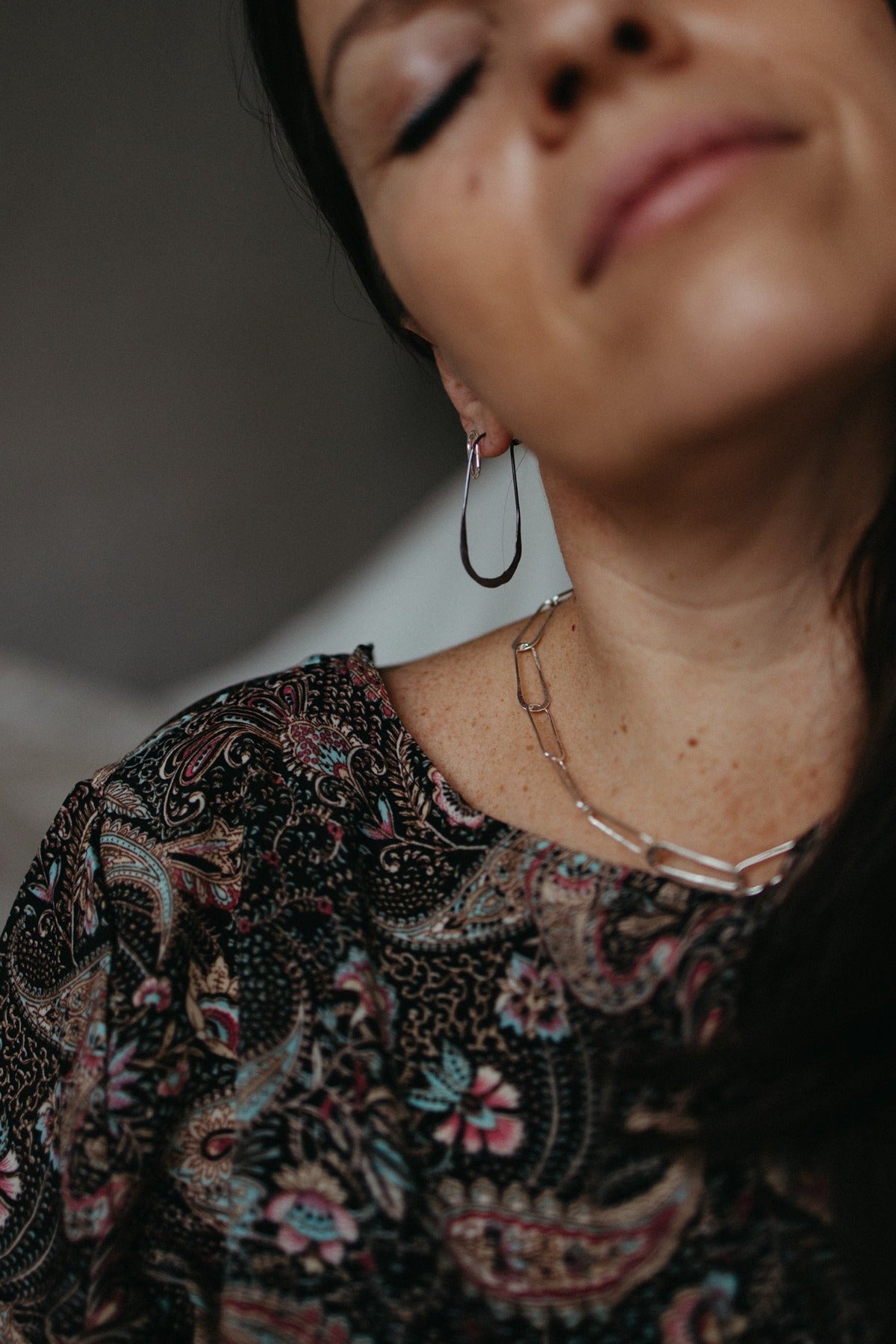 Charcoal hammered oval hoop earrings styled with silver oval stud earrings