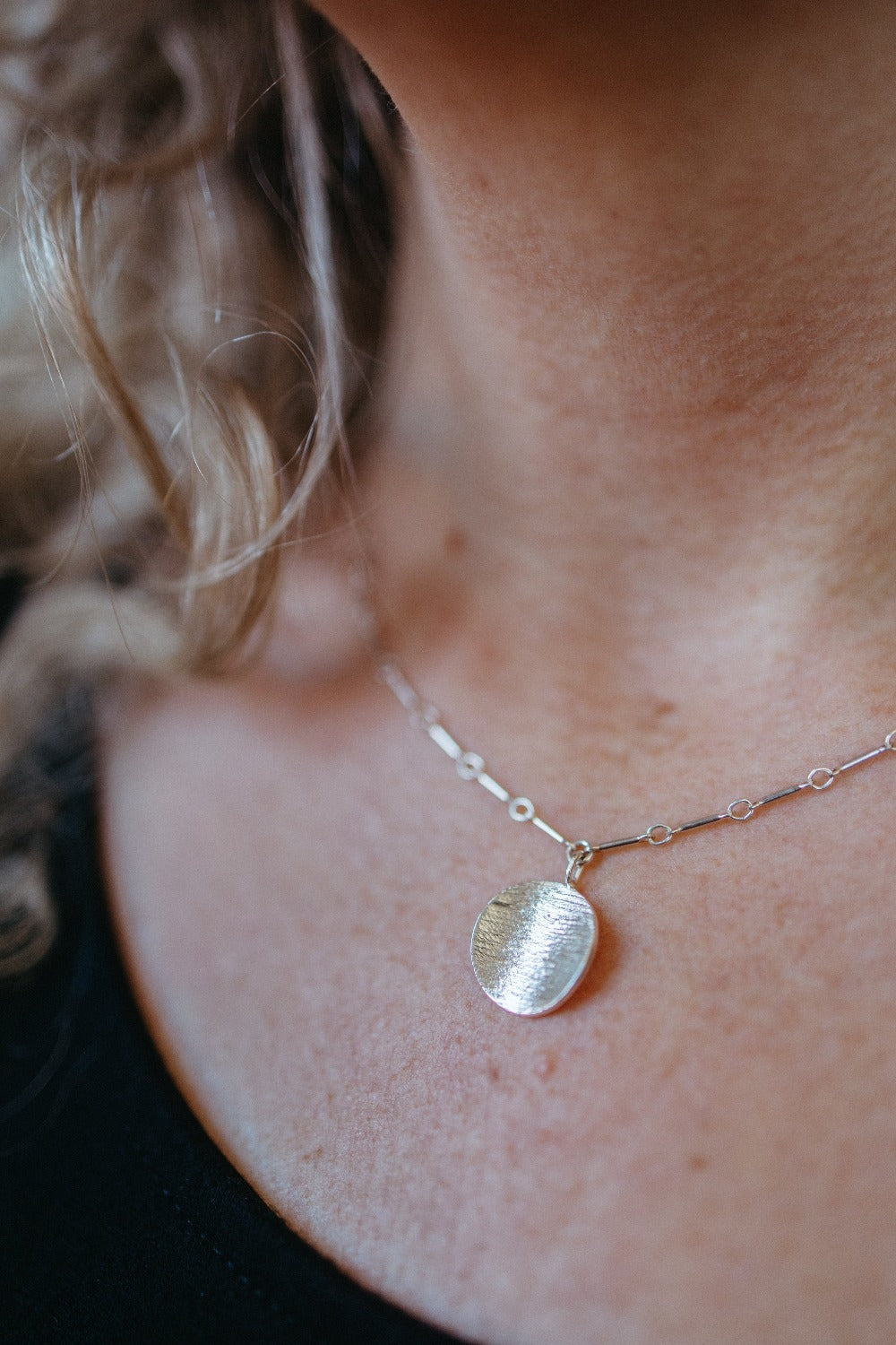 silver disk charm necklace on model