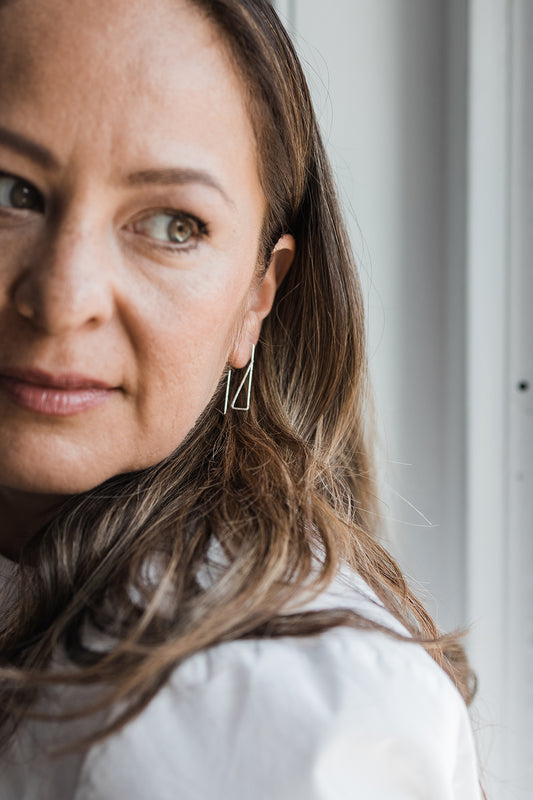 Silver geometric wire hoop earrings styled on model