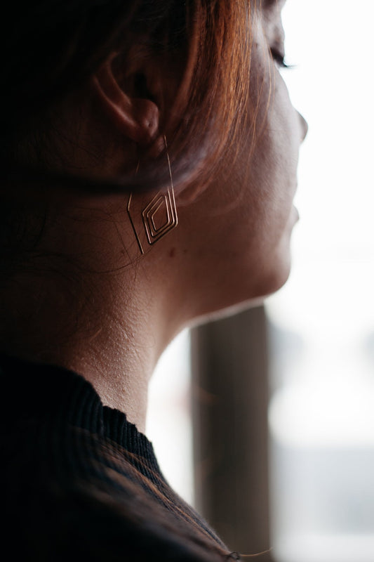 model wearing Diamond spiral pull-through hoops in gold