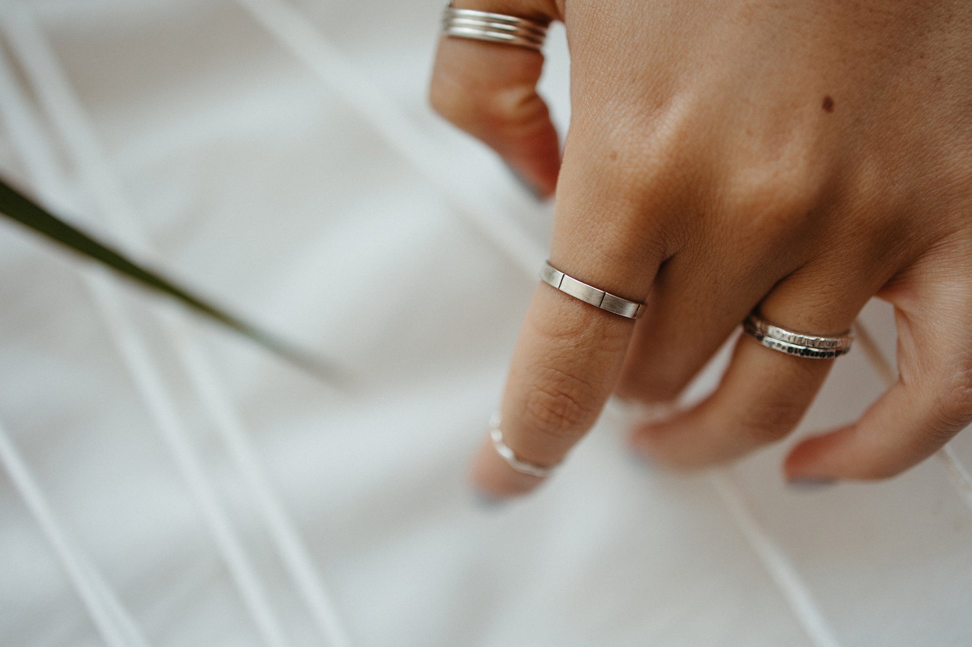 Silver midi lined ring paired with textured stacking rings styled on model