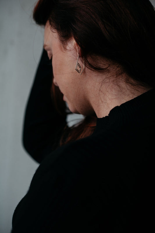 Gold diamond spiral hoop earrings styled on model