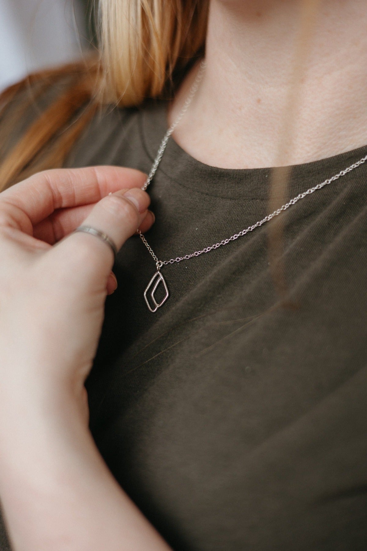Diamond-shaped pendant necklace styled on model