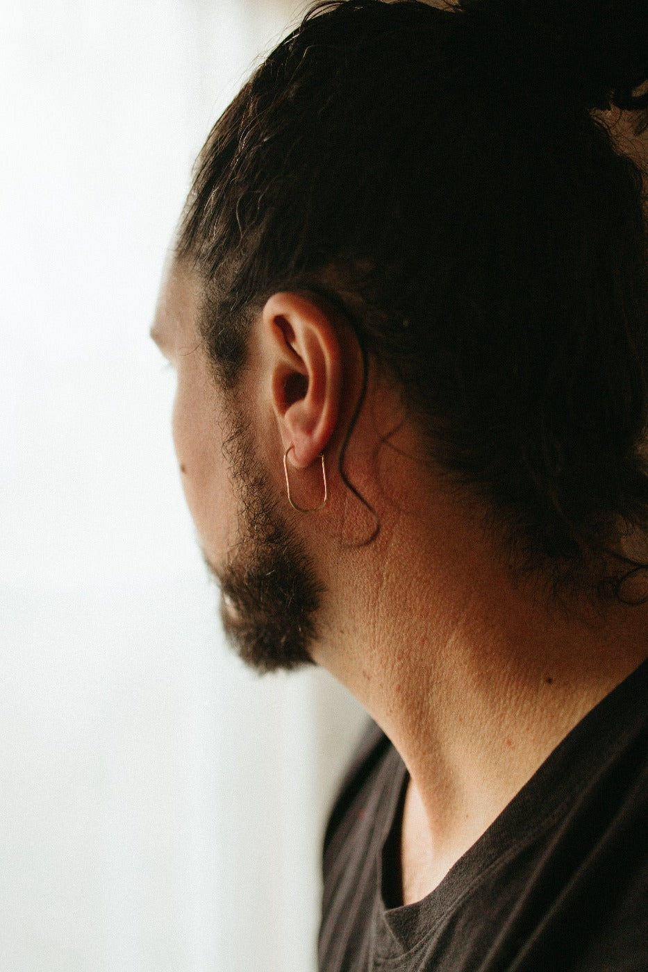 model wearing micro oval hoop earrings