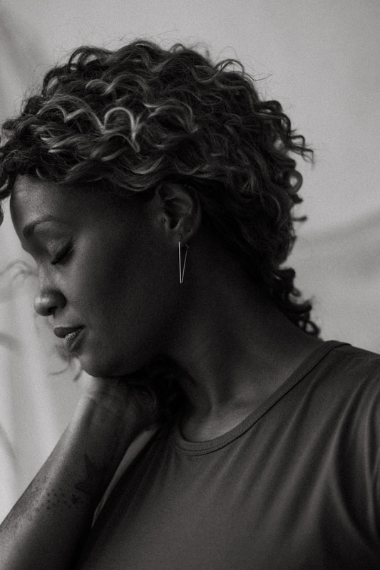 Small silver triangle dagger hoop earrings styled on model