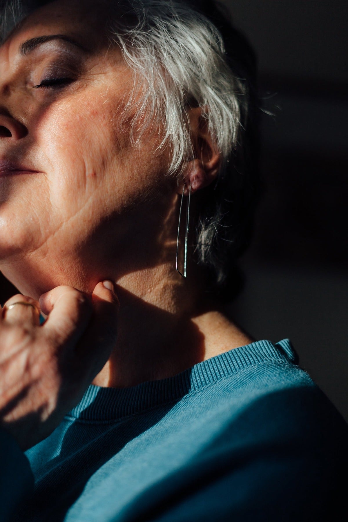 Long silver triangle hoop earrings styled on model