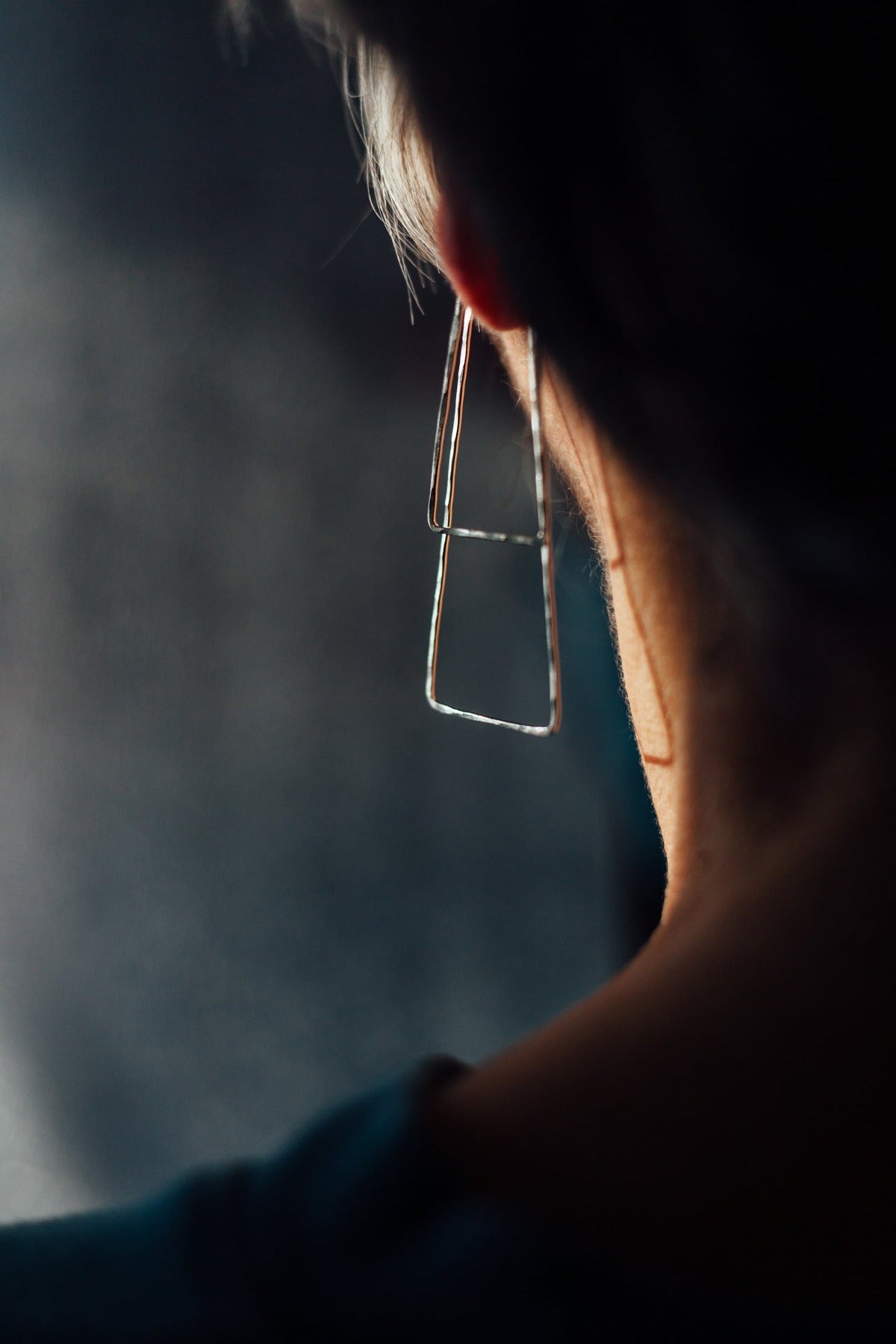 Delicate triangle hoop earrings styled on model