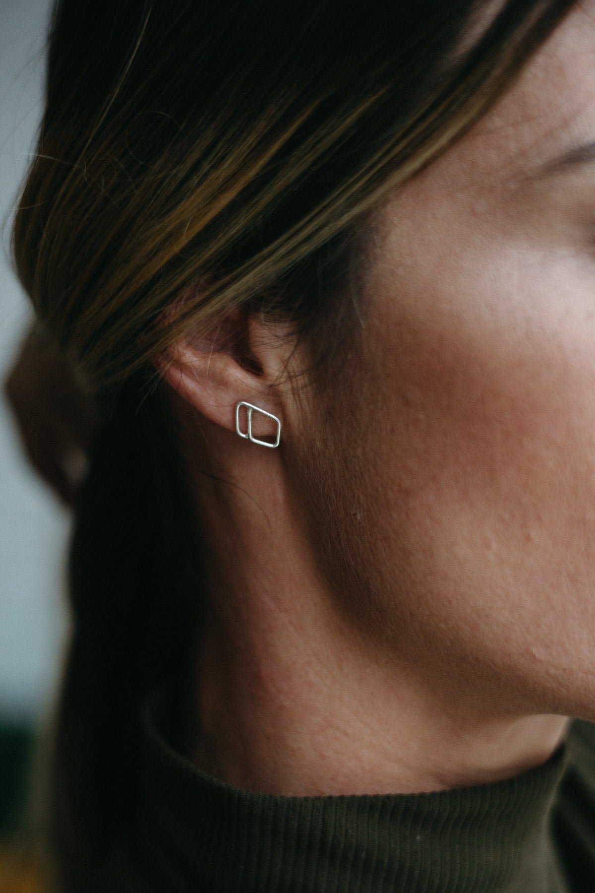 Silver halo diamond studs styled on model