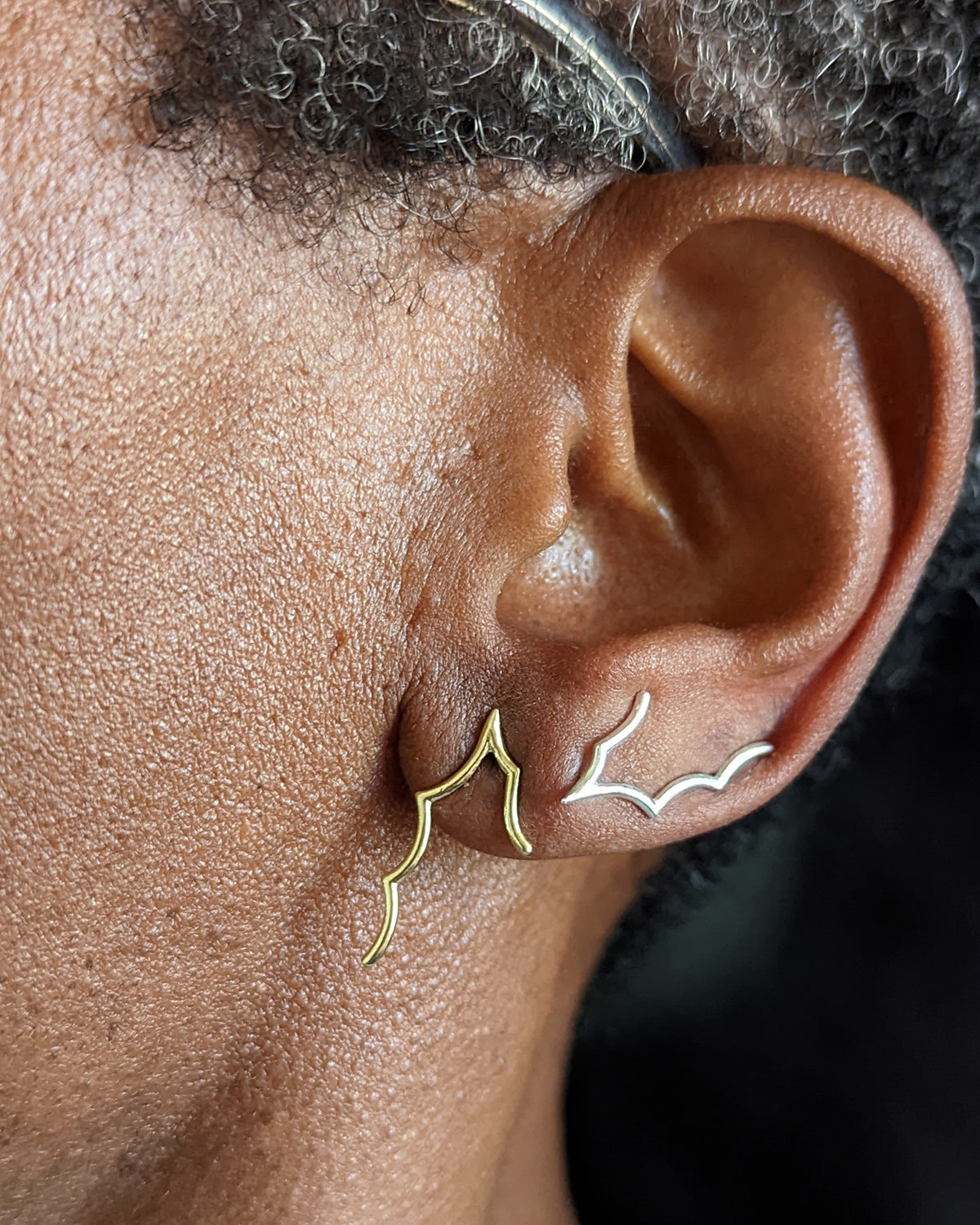 Spiderweb ear climbers in gold and silver styled by model