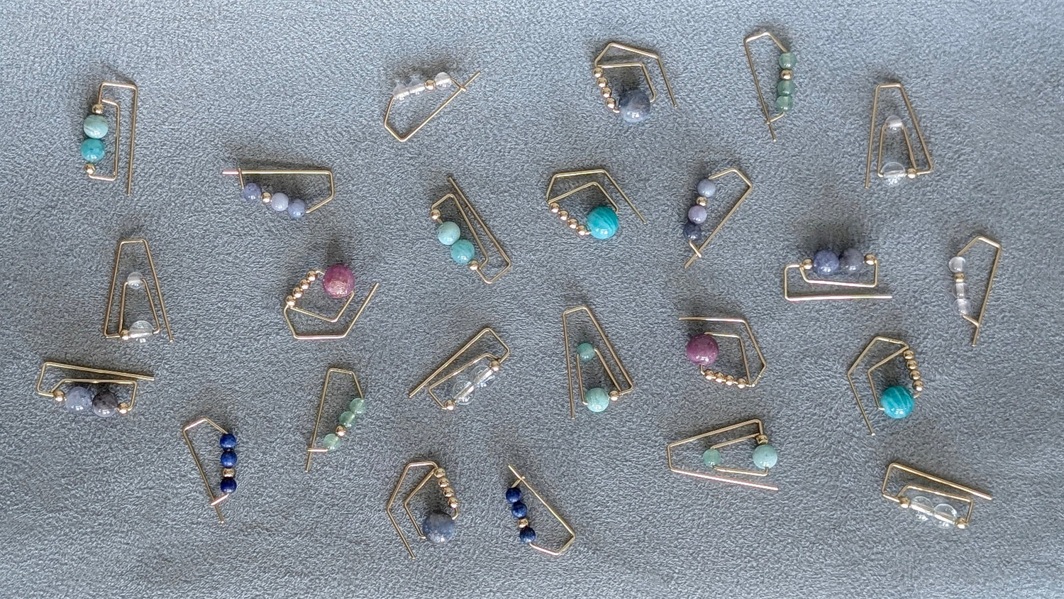 A flat lay of 14K gold hoops with colorful gemstones 
