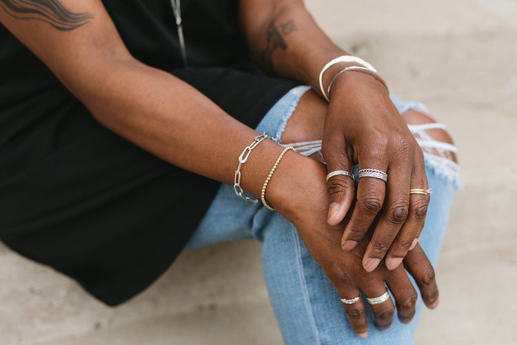 model wearing oval link bracelet with layered bracelets and rings