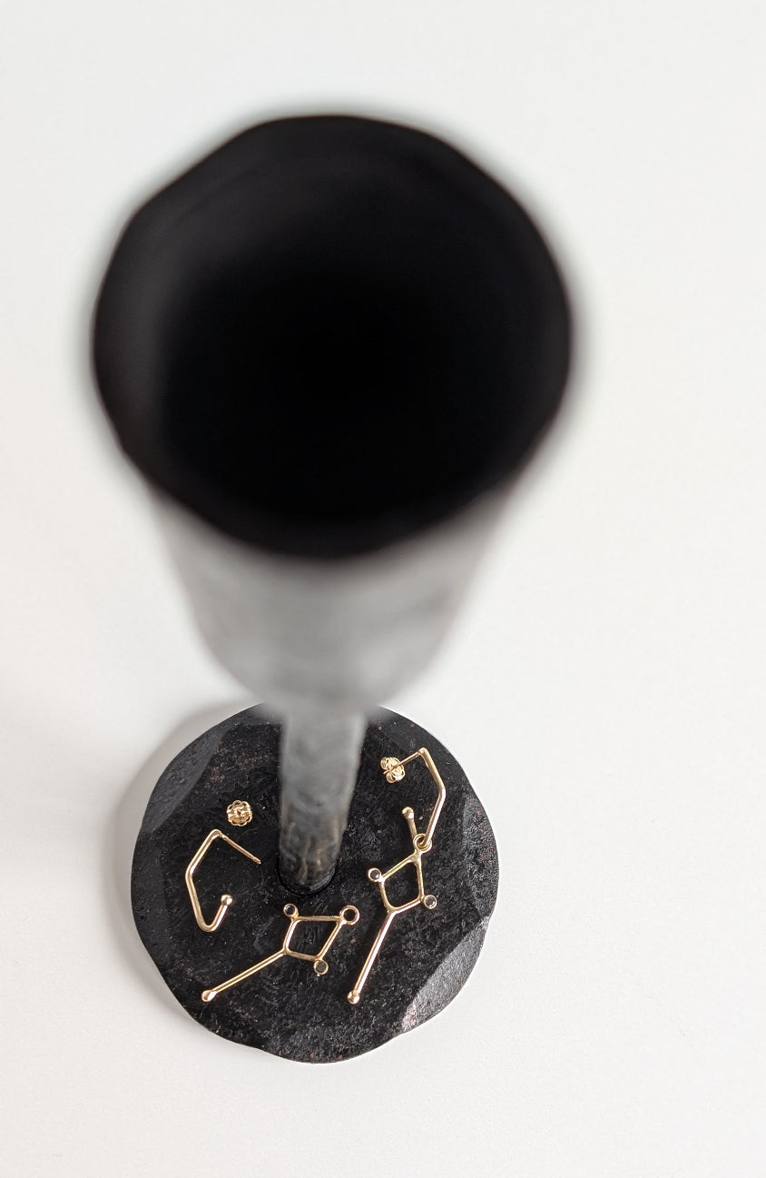 Black stone with gold astrological symbol on a white background