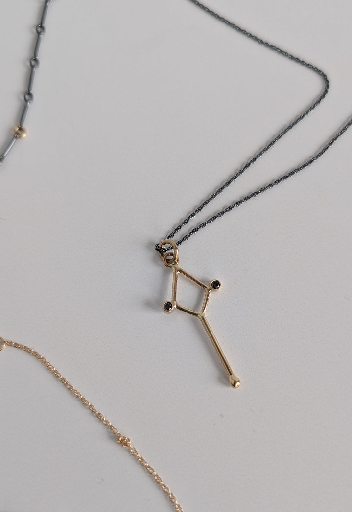 Gold necklace with star-shaped pendant on a light gray background