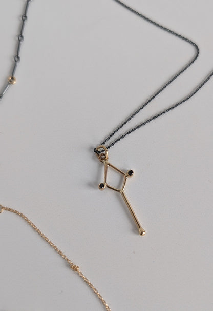 Gold necklace with star-shaped pendant on a light gray background