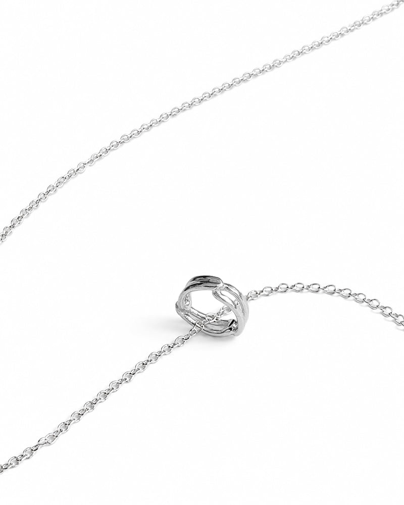 A silver chain necklace featuring a central interlocking double-ring pendant, displayed on a clean white background.