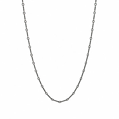 A delicate black chain necklace with small, evenly spaced open circle links, displayed in a U-shape against a solid white background.