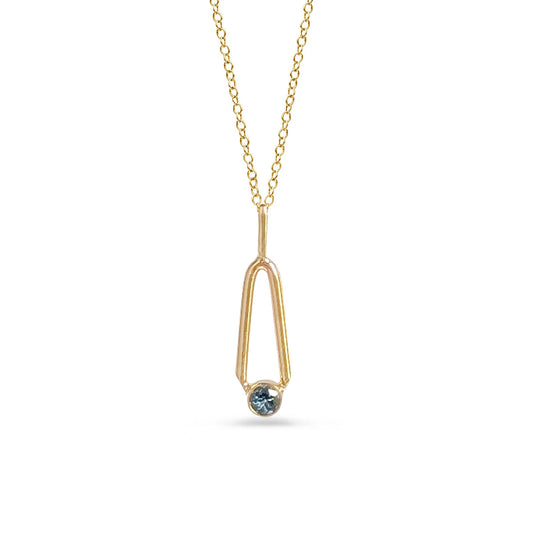 Gold necklace with a blue gemstone pendant on a white background