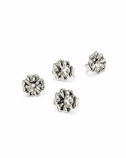 Four silver flower-shaped 7mm earring backs arranged on a plain white background.