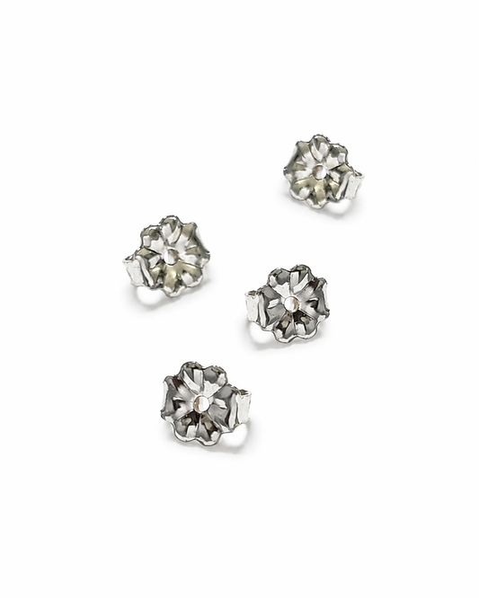 Four silver flower-shaped 5mm earring backs arranged on a plain white background.