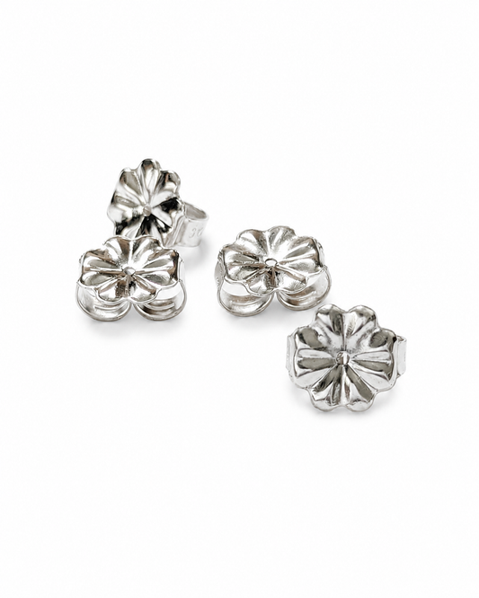 Four silver flower-shaped 9mm earring backs arranged on a plain white background.