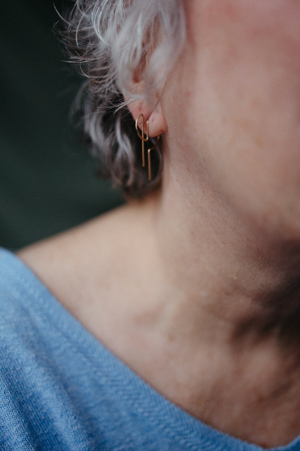 Model wearing 14K gold D hoop earrings 