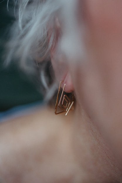 model wearing dainty trapezoid earrings with spiral diamond hoops