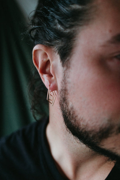 male model wearing spiral hoop earrings