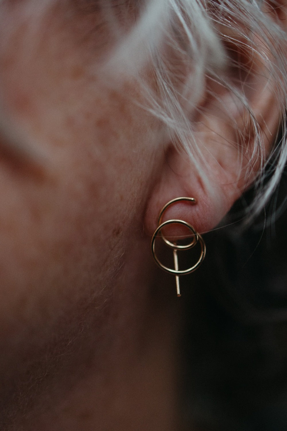 model wearing gold spiral earrings